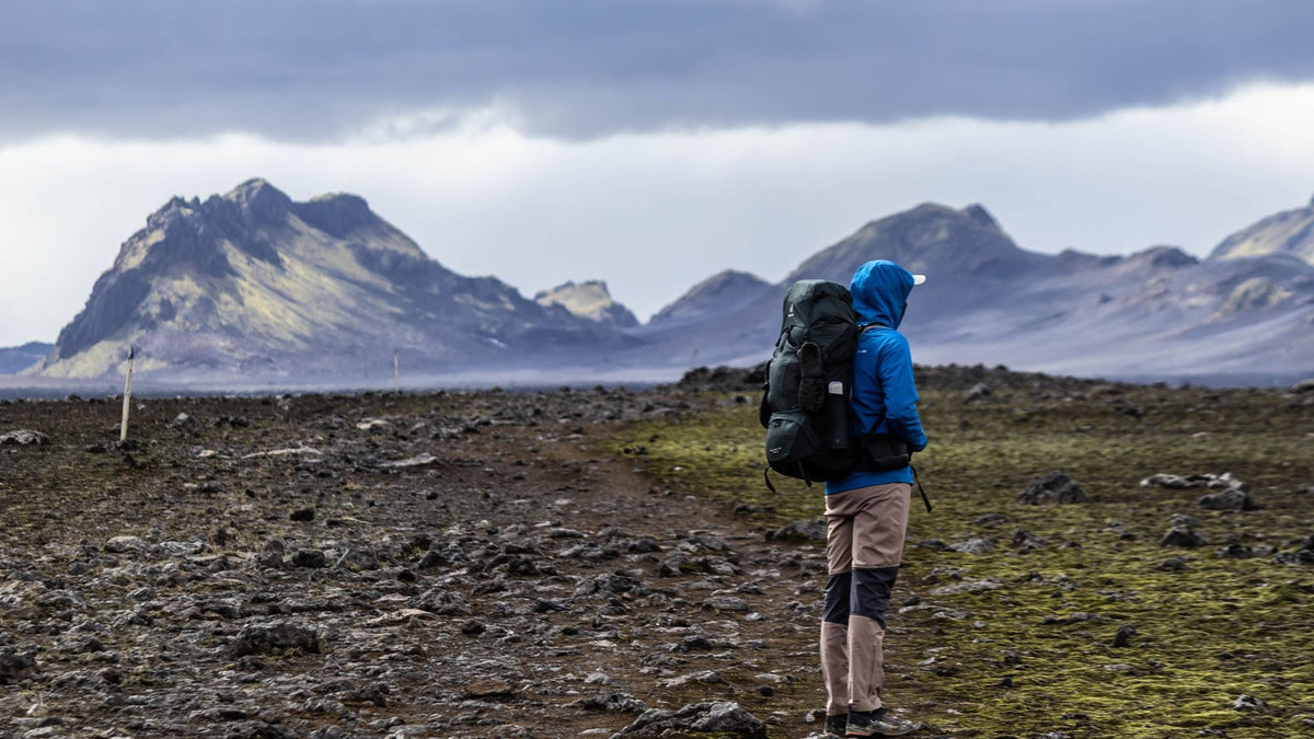 Excursionista con mochila cruzando un paisaje de tierras altas